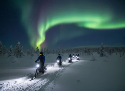 Guests driving Electric Reindeer on guide-led trails toward the Aurora Cabin
